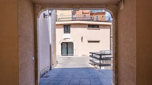 A narrow alleyway with a tiled floor leading to a building entrance. - Venuto Home by Wonderful Italy - Deep Blue (Catania)