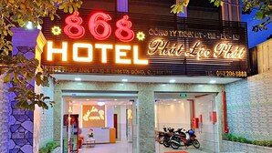 The exterior of 868 Hotel with a neon sign, reception area, and parked motorcycles. - S79 Hotel 868 Binh Tan (Ho Chi Minh City)