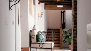 A hallway with a metal bench, a staircase, and a potted plant. - Charminghomesgranada Aljibe Antiguo Apartment (Granada)
