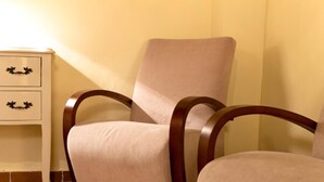 A chair with a wooden frame and a cushioned seat, positioned next to a white bedside table with drawers. - Charminghomesgranada Aljibe Granadino Apartament (Granada)
