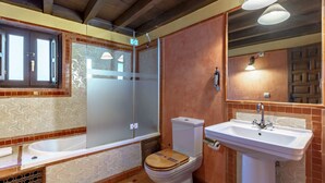 A bathroom with a bathtub, toilet, and sink.