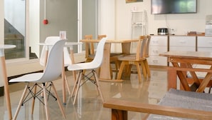 Een moderne keuken met houten meubels, een grote flatscreen-tv en een glazen deur naar een balkon.