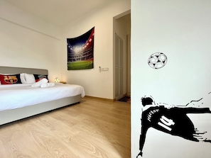 A hotel room with a bed, a wall tapestry, a door, and a wall decal. - Stunning Seaview Cosy Studio Apartment In Melaka (Malacca City)