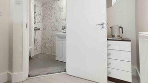 A modern bathroom with a shower, toilet, and sink.