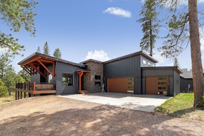 Une maison moderne dotée d’un porche abrité, d’un garage et d’une allée.