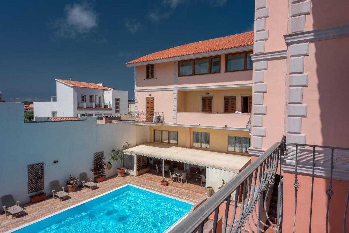 Un bâtiment à deux étages doté d’une piscine, d’un espace extérieur aménagé et d’un balcon.