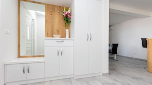 A modern room with a white wardrobe, a mirror, and a vase with flowers. - Apartments Peaceful Place (Stanici)