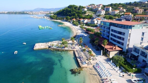 Un hôtel situé sur la côte, avec accès direct à la plage, comprenant une jetée et un espace de détente.