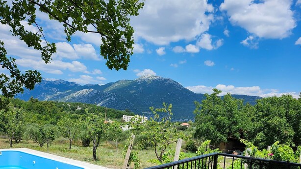 A balcony with a pool, chairs, and a table overlooking a vineyard and mountains. - House Sunset View (Kucice)