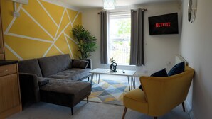 A modern living room with a sofa, armchair, and a coffee table. - Stunning 6-bed House in Milton Keynes (Milton Keynes)