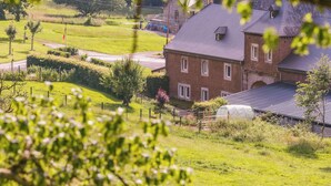 A rural house with a large garden, a greenhouse, and a barn.