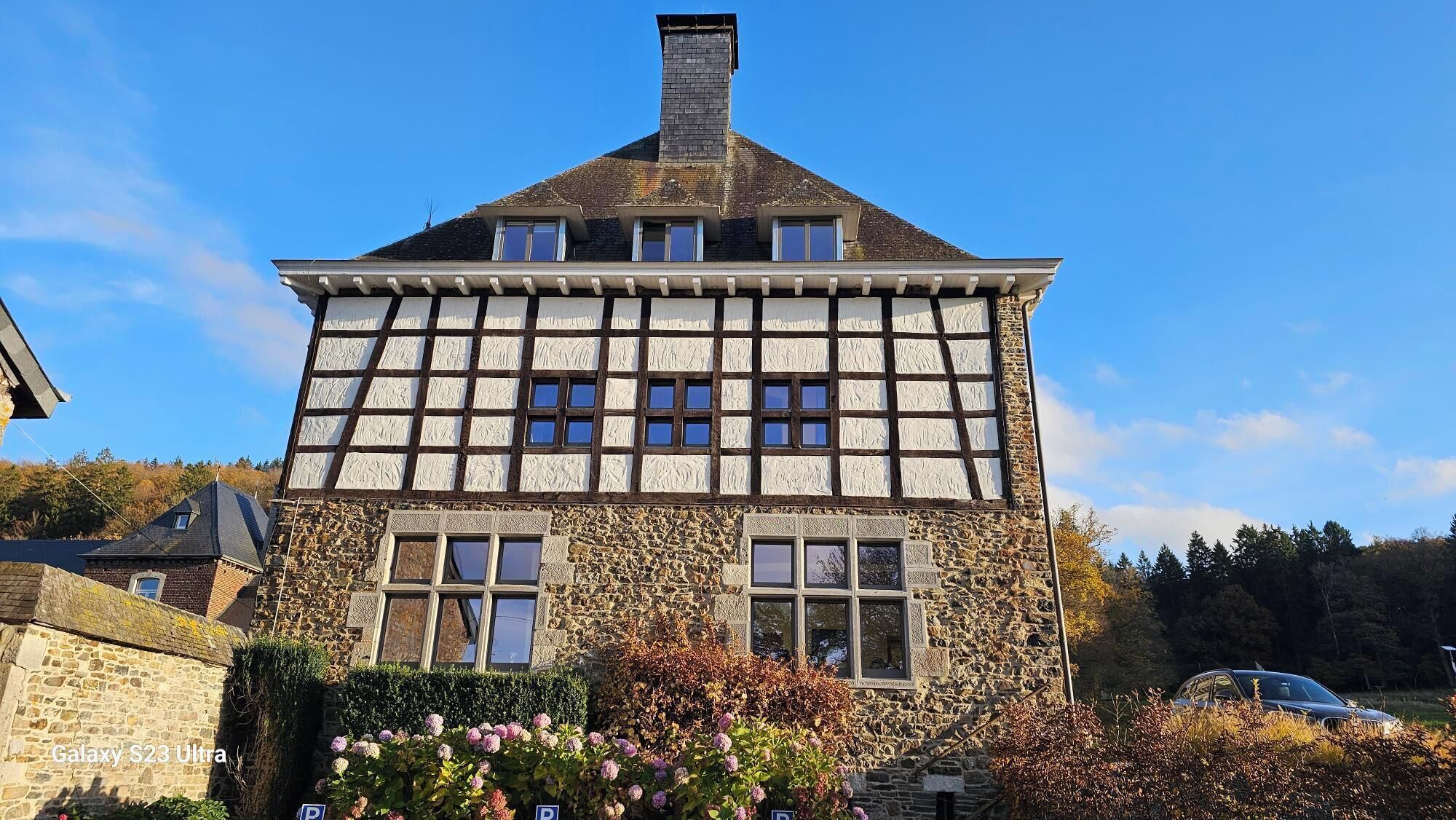 A traditional half-timbered house with stone walls and a steeply pitched roof.