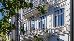 A historic building with ornate balconies, large windows, and a cobblestone street. - Old Town Luxury Suites (București)