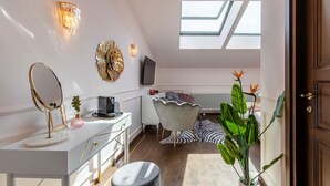 A modern interior with a white vanity, a round mirror, a television, a zebra-patterned rug, and a skylight. - Old Town Luxury Suites (București)