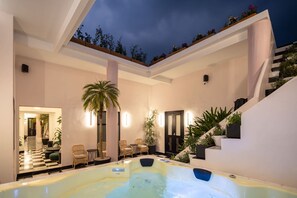 Ein moderner Innenpoolbereich mit Treppe, Liegestühlen und Topfpflanzen.