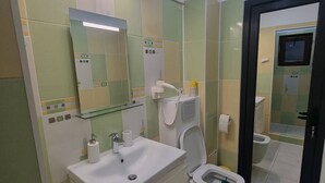 A modern bathroom with a toilet, sink, and mirror. - Rocktop Refuge In Rasnov (Rasnov)