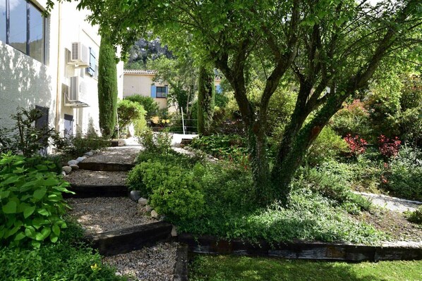 A garden with a stone pathway leading to a building.