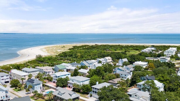 Una zona residenziale sul lungomare, con case, una spiaggia e una vista libera sull'oceano.