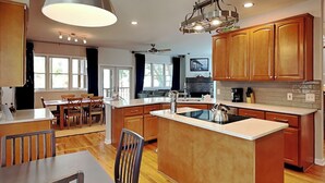 Una cucina moderna con mobili in legno, un'isola centrale e un'area pranzo con sedie e tavolo.