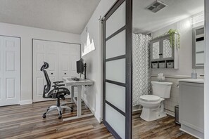 A modern bathroom with a toilet, sink, and cabinet.