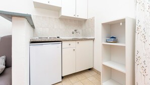 A compact kitchen with white cabinets, a dishwasher, and a small countertop.
