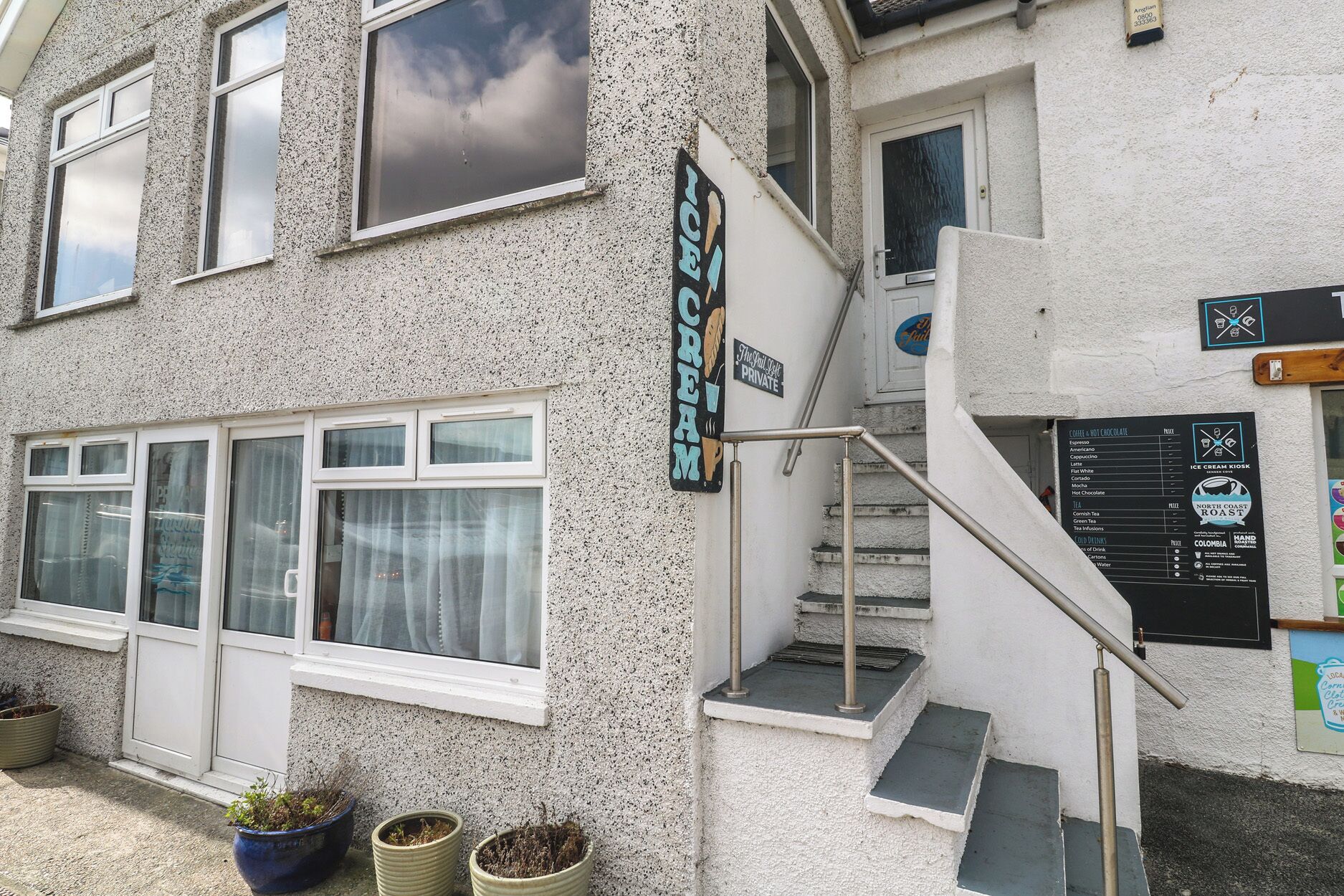 Ein Gebäude mit einem Schild für 'The Chill Spot Private' und einer Speisekarte für 'North Coast Roast'.