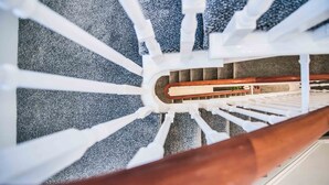 A spiral staircase with white railings and a wooden handrail. - Apartment 3 - The Crescent (York)