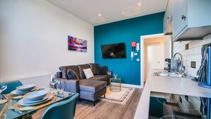 A modern living room with a sofa, dining table, and kitchen area. - Apartment 3 - The Crescent (York)