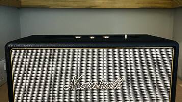 Un amplificador Marshall negre sobre una prestatgeria de fusta.