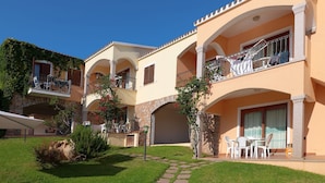 A multi-story hotel with balconies, outdoor seating, and a stone archway. - The Fantastic Residenza Badus Studio Sleeps 2 Num0828 (Badesi)