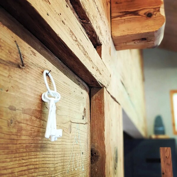 A wooden wall with a keychain and a small hook.
