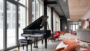 A grand piano in a spacious room with large windows, modern furniture, and a bar area. - Wifi, ski-in/ski-out & foot of the slopes, view ski slopes, fitness, swimming pool, sauna, hammam (Flaine)