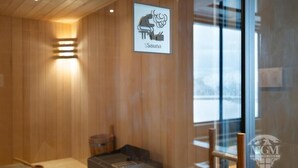 Un sauna avec des murs en bois, un banc et un panneau indiquant l’emplacement du sauna.