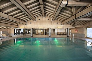 A large indoor swimming pool with a wooden ceiling and seating areas. - Wifi, ski-in/ski-out & foot of the slopes, view mountain, fitness, swimming pool, sauna, hammam (Manigod)