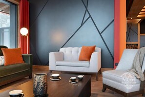 A modern living room with a white sofa, green and white armchairs, and a wooden coffee table with cups and a decorative vase. - Wifi, ski-in/ski-out & foot of the slopes, view mountain, fitness, swimming pool, sauna, hammam (Manigod)