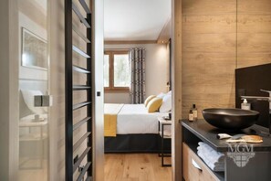 A modern hotel room with a bed, bedside table, and a large black sink. - Wifi, ski-in/ski-out & foot of the slopes, view mountain, fitness, swimming pool, sauna, hammam (Manigod)