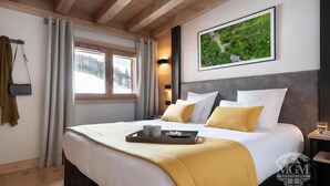 A hotel room with a large bed, a window with curtains, a framed picture on the wall, and a tray with cups and a book on the bed. - Wifi, ski-in/ski-out & foot of the slopes, fitness, swimming pool, sauna, hammam, balcony, tv, 45m² (Manigod)