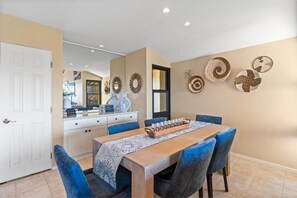 A dining area with a wooden table, blue chairs, and decorative wall art.