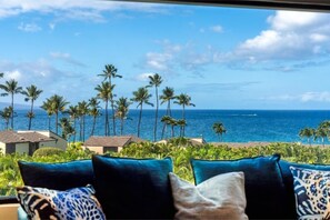 A view from a window overlooking a beach with palm trees and ocean. - Wailea Elua, #0802 2 Bedroom Condo by RedAwning (Kihei)