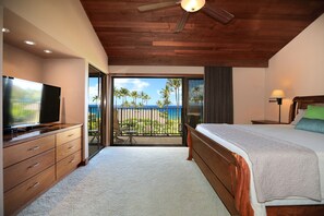A bedroom with a large bed, a television, a ceiling fan, and a view of the ocean through a sliding glass door. - Wailea Elua, #1508 2 Bedroom Condo by RedAwning (Kihei)