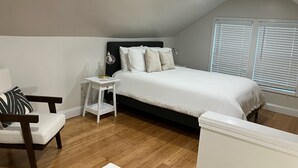 A bedroom with a bed, bedside table, chair, and a window with blinds. - 5 Points House - Great Location - 3Br2Ba - Early Check-In (Athens)