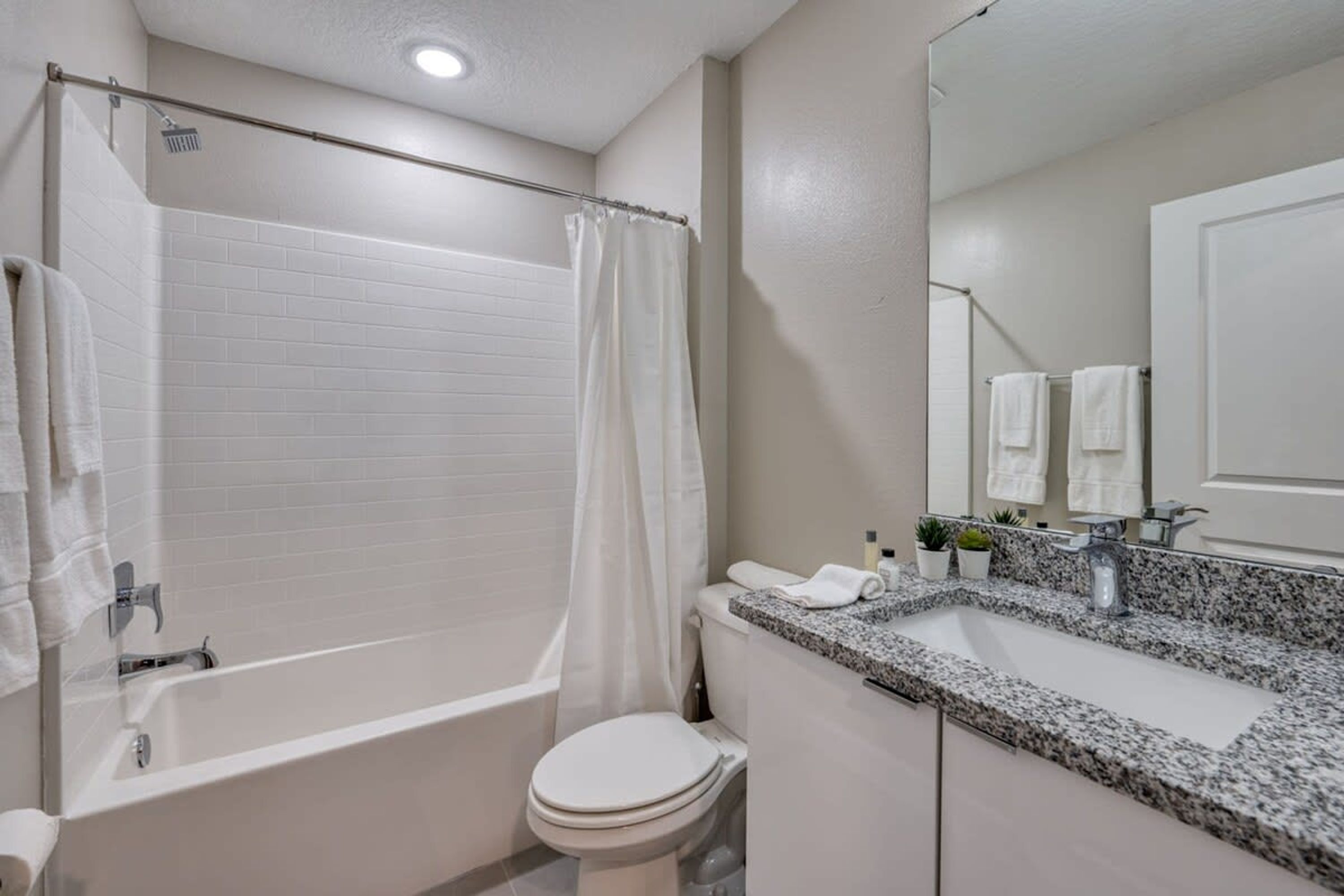 A modern bathroom with a bathtub, toilet, and sink.