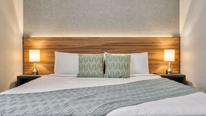 A neatly made bed with a patterned blanket, two pillows, and two bedside lamps on wooden nightstands. - Spacious and Modern Home for 9 Guests (Kissimmee)