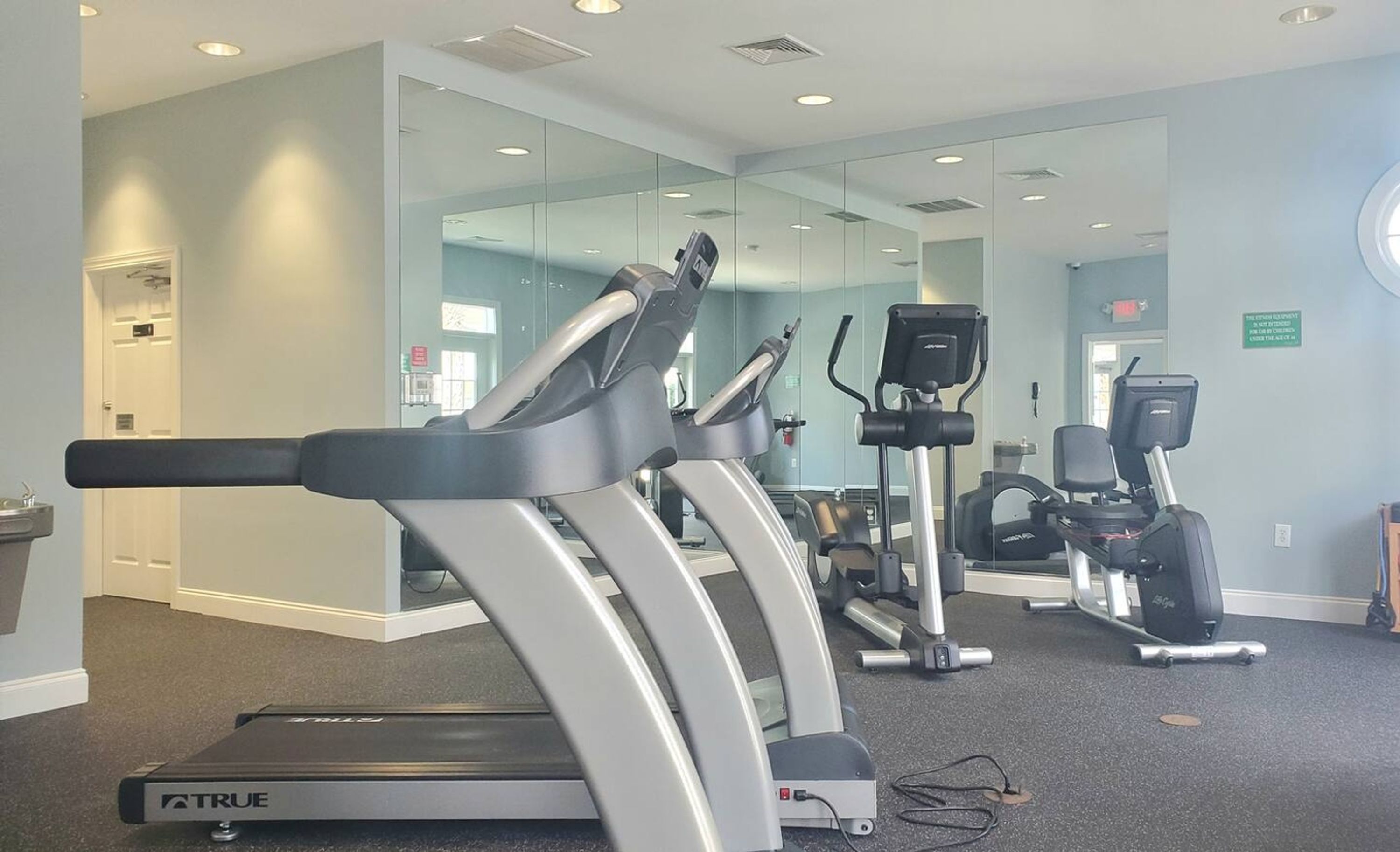 A fitness center with treadmills, elliptical machines, and exercise equipment.