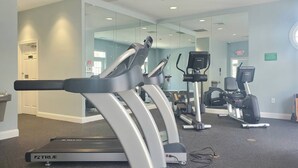 Un gimnasio con cintas de correr, elípticas y equipo de ejercicio.