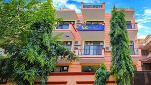 Un edificio de varios pisos con un letrero de 'fab hotels', con balcones y un diseño arquitectónico moderno.