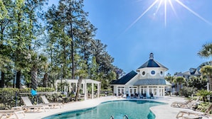 A pool area with lounge chairs, a gazebo, and a building with a dome and blue roof. - Mini Oasis Studio 10 Min to All Myrtle Beach (Myrtle Beach)