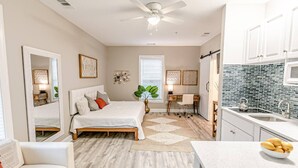 A bedroom with a bed, bedside tables, a desk, and a chair. - Mini Oasis Studio 10 Min to All Myrtle Beach (Myrtle Beach)
