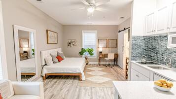 A bedroom with a bed, bedside tables, a desk, and a chair.