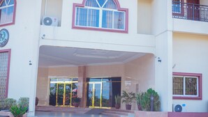A two-story building with a central entrance, large windows, and a balcony on the upper floor. - Eden Hotels Ltd (Eket)